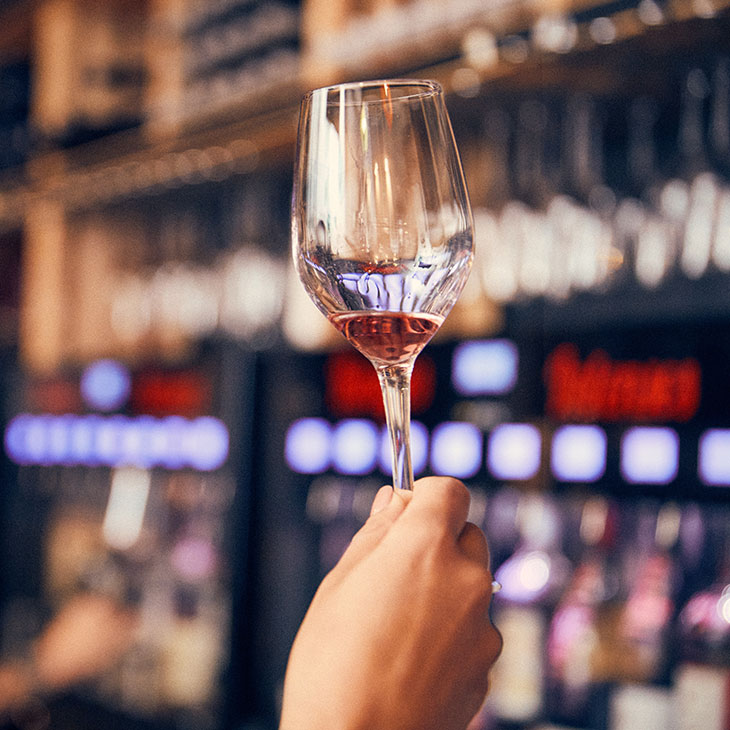 Photo d'un verre de vin rouge avec bouteille et caraphe arrière plan